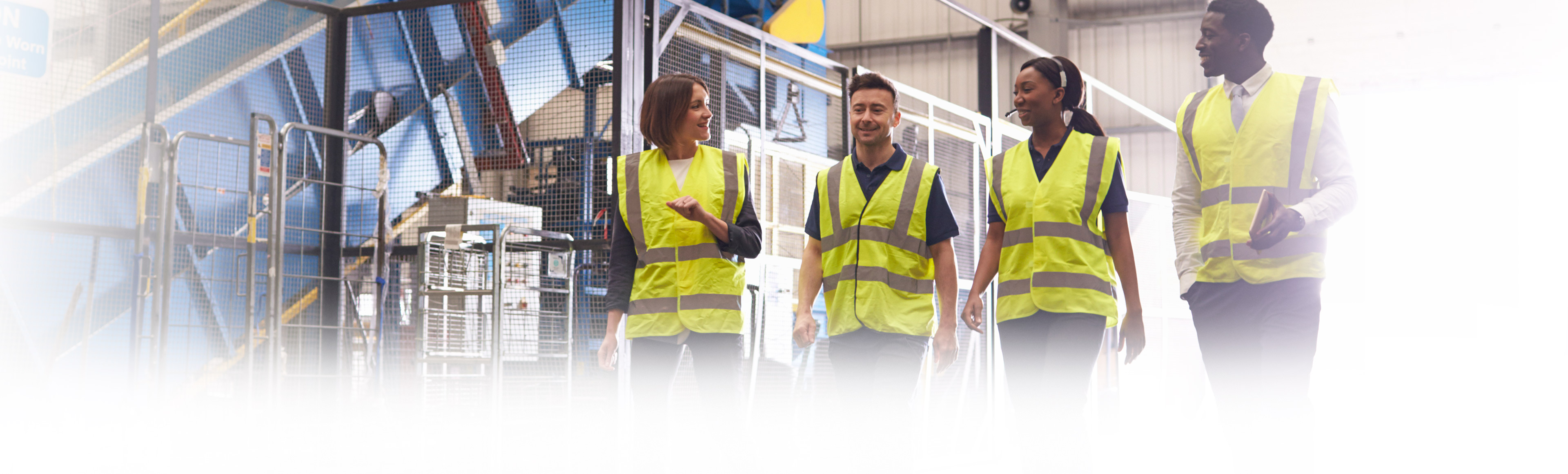 Four colleagues walking together in yellow safety vests